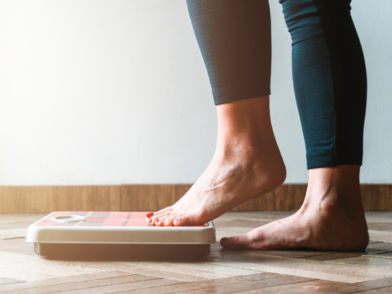 Woman stepping on body weight scales